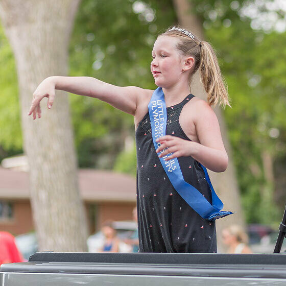 A little girl throwing candy from a parade float during Ice Cream Days in Le Mars.