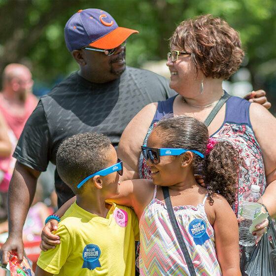 A man, his wife, daughter, and son laughing and smiling during ice cream days in le mars.
