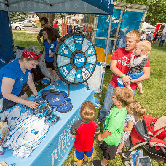 A family standing in front of the Blue Ribbon classics booth during Ice Cream Days in Le Mars.